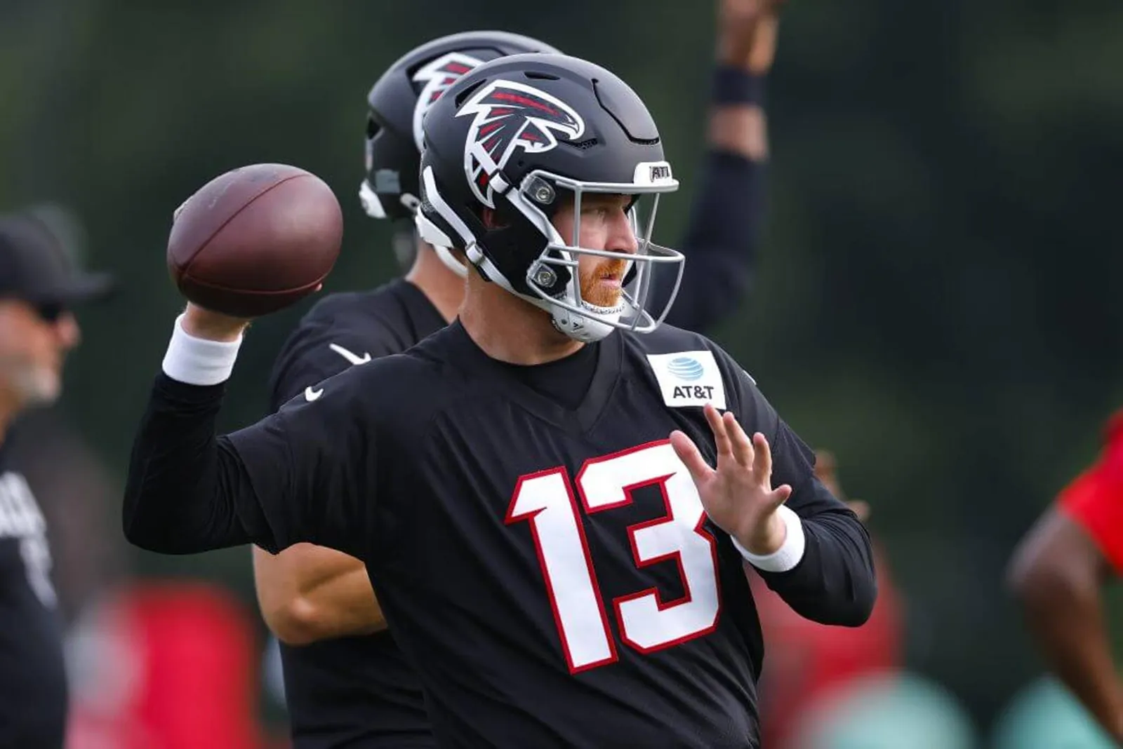 Falcons quarterback Cooper Rush cocks his arm to throw a pass during a practice.